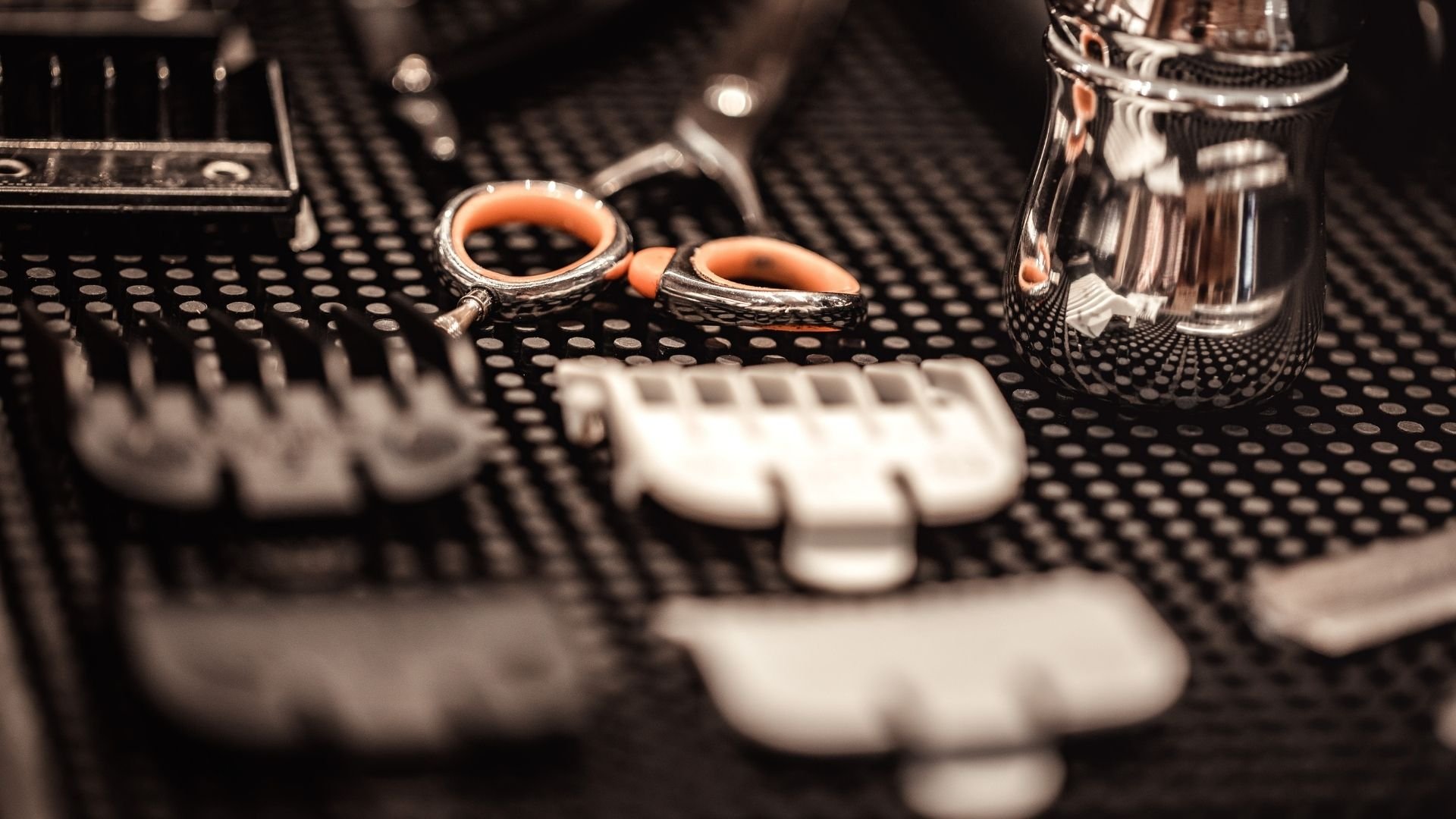 Ornate cuff links with orange stones on textured black surface with jewelry.
