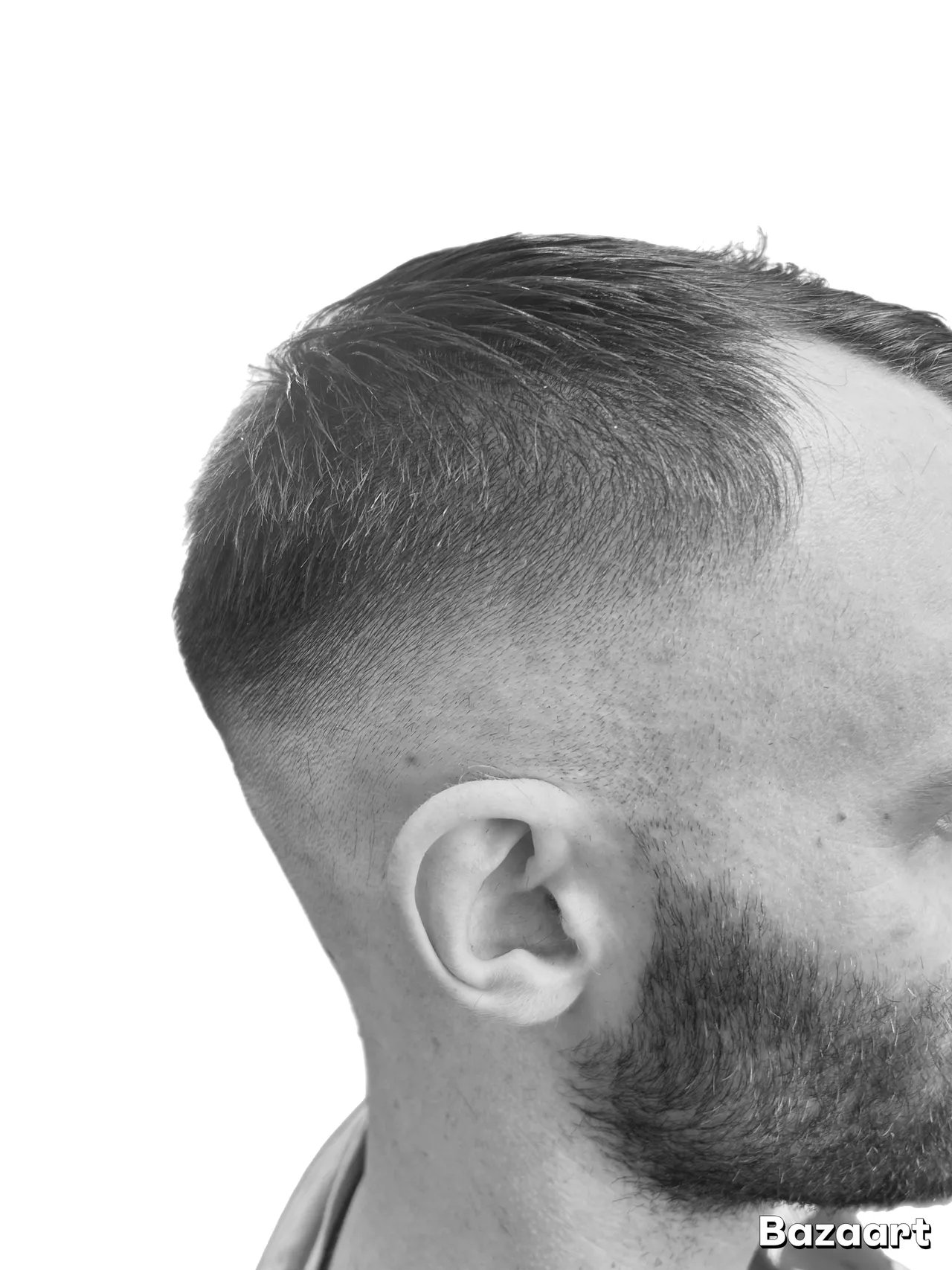 Side profile of man with short dark hair and beard against white background